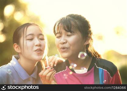 couples of asian teenager relaxing with soup bubble against beautiful sun light