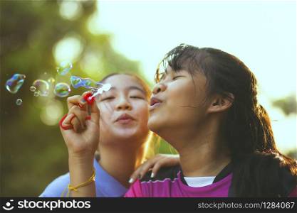 couples of asian teenager relaxing with soup bubble against beautiful sun light