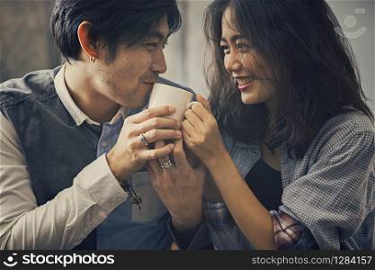 couples of asian younger man and woman happiness emotion with hot coffee cup in hand