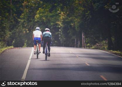 couples of man riding touring bicycle on mountain road