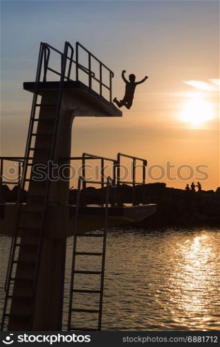 Courage and Jump: Silhouette of Child Jumping from High Board into Water, Fun in the Summer