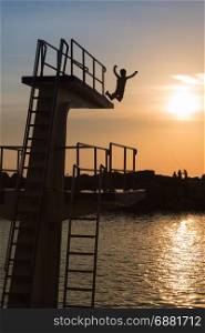 Courage and Jump: Silhouette of Child Jumping from High Board into Water, Fun in the Summer