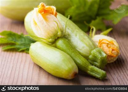 Courgettes with flowers on wooden backgorund