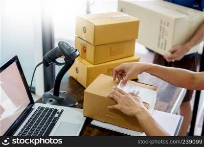 Courier hands Business woman work at home office checking parcel package box by keying machine track tools before ship and documents data.