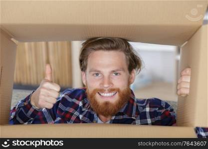 courier with thumb up inside of a box