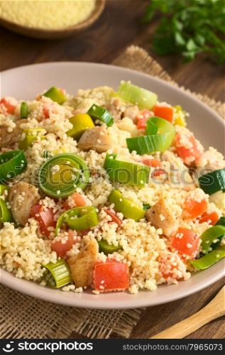 Couscous dish with chicken, leek and tomato served on plate, photographed with natural light (Selective Focus, Focus one third into the dish)