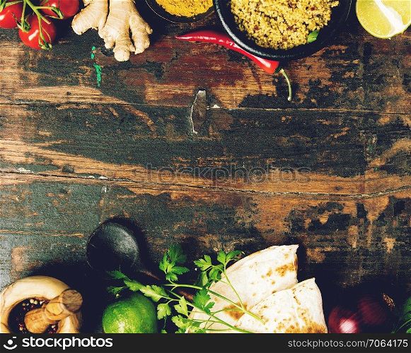 Couscous, naan bread and cooking ingredients on old wood background. Flat lay. Healthy vegetarian food and cooking concept. Cooking ingredients on wooden background