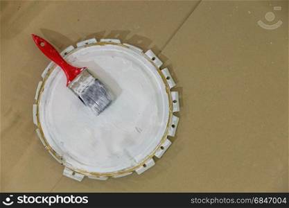 cover of can with white paint and brush for painting renovation interior
