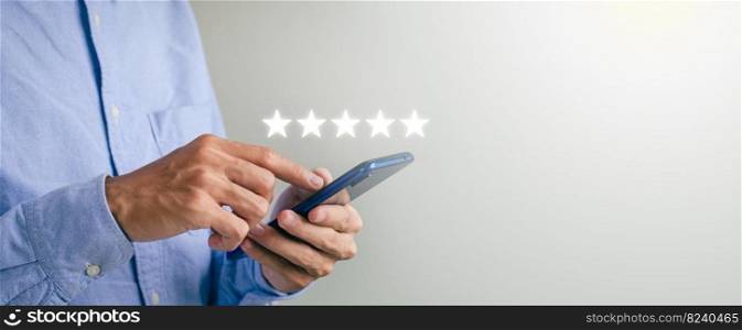Cover the guy’s hand using a smartphone and give the five-star symbol to increase the customer service rating of the company concept. customer service experience and satisfaction surveys