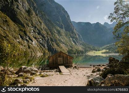 Covered pier over a German lake among the mountains at sunset with descending paths
