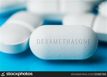 COVID-19 corticosteroid medication drug DEXAMETHASONE,pile of white pills with letters engraved on side,potential experimental WHO Coronavirus cure,pandemic outbreak crisis,US antiviral clinical trial