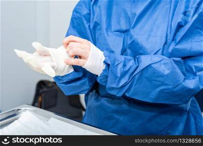 Covid-19. Doctor puts on protective gloves. Personal protective equipment in the fight against Coronavirus disease .. Covid-19. Doctor puts on protective gloves. Personal protective equipment in the fight against Coronavirus disease.