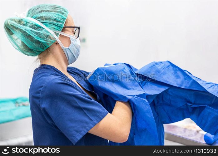 Covid-19. Female nurse puts on protective cloths. Personal protective equipment in the fight against Coronavirus disease .. Covid-19. Female nurse puts on protective cloths. Personal protective equipment in the fight against Coronavirus disease.