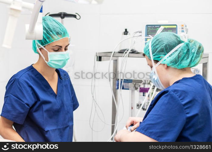 Covid-19 outbreak. Healthcare worker. Nurse working in intensive care unit. Mechanical ventilation system in the background .. Covid-19 outbreak. Healthcare worker. Nurse working in intensive care unit. Mechanical ventilation system in the background.