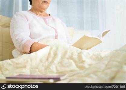 Covid-19 quarantine activity for senior woman read a book stay home to avoid risk
