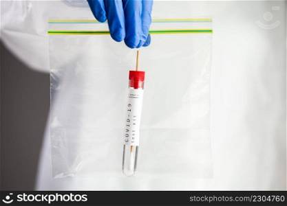 COVID-19 virus disease self swab test s&le kit, medical laboratory scientist holding a plastic bag containing test tube with throat or nose swab viral specimen collection equipment, Coronavirus
