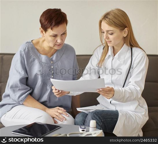 covid recovery center female doctor checking health results with elder patient