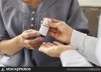 covid recovery center female doctor giving elder patient pills bottle