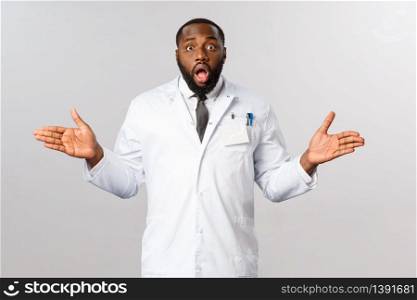 Covid19, healthcare and clinic concept. Portrait of surprised african-american doctor, spread hands sideways puzzled, gasping and staring startled camera, cant understand how it happened.. Covid19, healthcare and clinic concept. Portrait of surprised african-american doctor, spread hands sideways puzzled, gasping and staring startled camera, cant understand how it happened