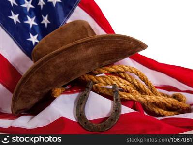 cowboy hat, lasso and horseshoe lying on the usa flag isolated on white background. flag horseshoe hat
