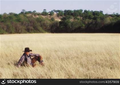 Cowboy sitting on a field, Texas, USA