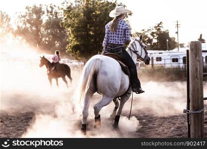 Cowgirl Riding Horse in a Dusty Arena at Dusk Golden Hour Glow Equestrian Rodeo