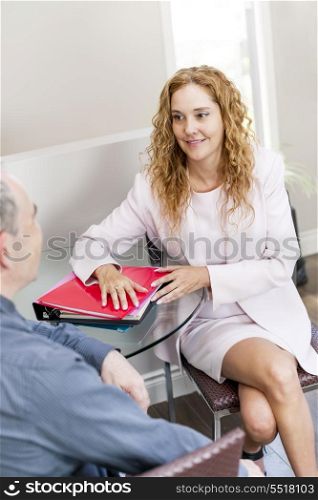 Coworkers at business meeting in office. Man and woman discussing business in office