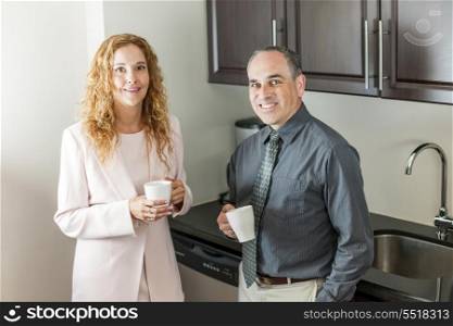 Coworkers on coffee break. Two office coworkers on coffee break standing in kitchen