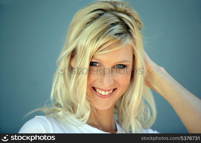 Coy blond woman touching hair