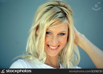 Coy blond woman touching hair