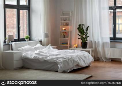coziness and interior concept - cozy bedroom with white linen on bed. cozy bedroom with white linen on bed