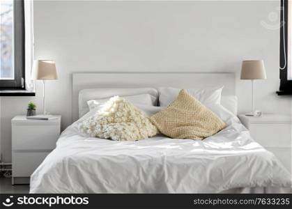 coziness, interior and living concept - cozy bedroom with cushions and bed linen at home. cozy bedroom with cushions and bed linen at home