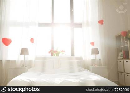 coziness, interior and romantic date concept - cozy bedroom decorated for valentines day. cozy bedroom decorated for valentines day