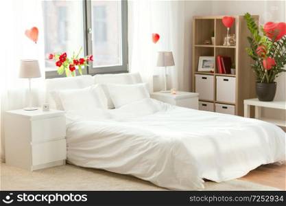 coziness, interior and romantic date concept - cozy home bedroom decorated for valentines day. cozy bedroom decorated for valentines day