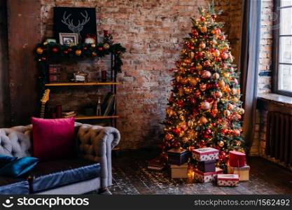 Cozy apartment with brick walls and brightly decorated Christmas tree with bunch of presents under it. . Cozy apartment decorated for Christmas