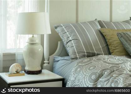 cozy bedroom interior with pillows and reading lamp on bedside table