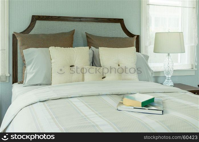 cozy bedroom interior with white pillows and reading lamp on bedside table