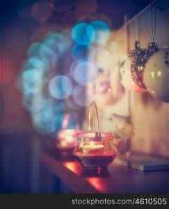 Cozy Christmas decoration with candles and festive bokeh lighting in room.