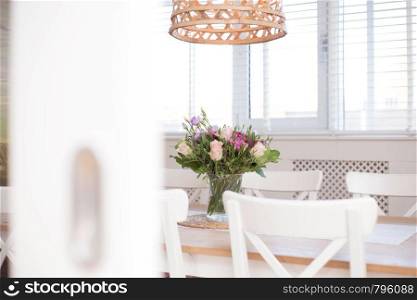 cozy dining room interior with flower decoration in a white room of a modern house close-up colorful. cozy dining room interior with flower decoration in a white room of a modern house close-up