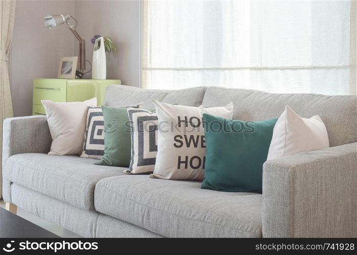 Cozy gray sofa with geometry pattern pillows in modern living room