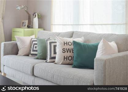 Cozy gray sofa with geometry pattern pillows in modern living room
