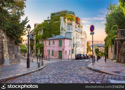 Cozy old street with pink house at the sunny sunrise, quarter Montmartre in Paris, France. Montmartre in Paris, France