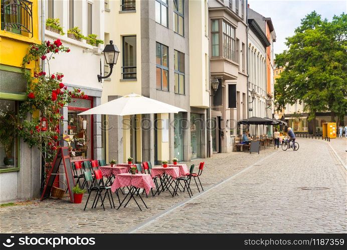 Cozy street cafe decorated with flowers in old European tourist town. Summer tourism and travels, famous europe landmark, popular places for travelling