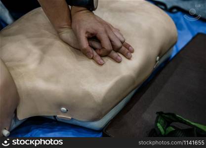 CPR first aid resuscitation training class. chest compression on dummy.