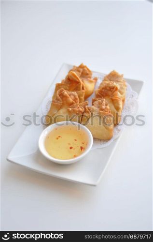Crab Rangoon. Cream cheese, crab-meat, celery wrapped in thin crape and fried. Served with light sweet & sour sauce.