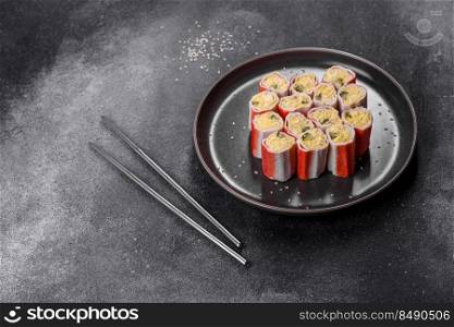 Crab sticks stuffed with rice, egg and green onions on a dark gray background. Crab sticks stuffed with rice, egg and green onions
