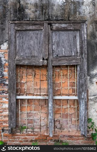 Cracked and decayed brick stucco wall texture background with old vintage window frame weathered long time ago.