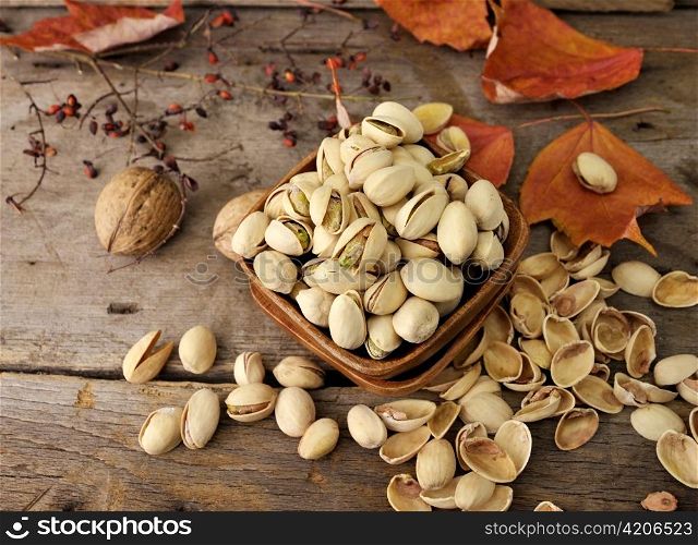 Cracked and Dried Pistachio Nuts In A Wooden Bowl