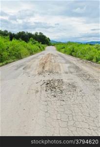 Cracked asphalt countryside road