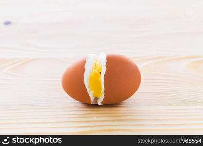 Cracked eggs in the middle on the wooden floor.